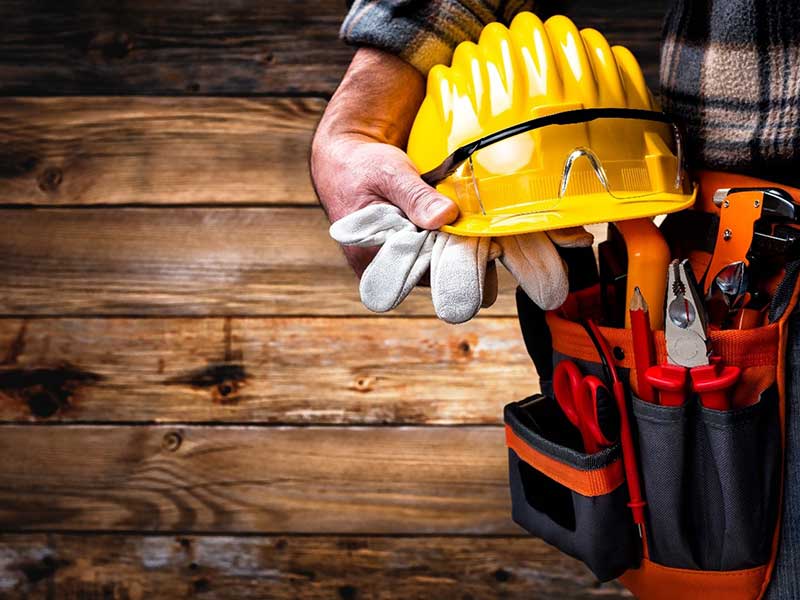 A construction worker holding a helmet