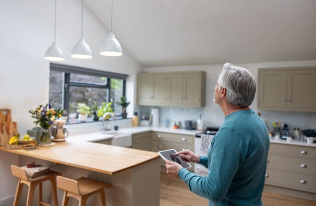 A man using a tablet in a modern kitchen, showcasing home automation technology in Frederick, MD
